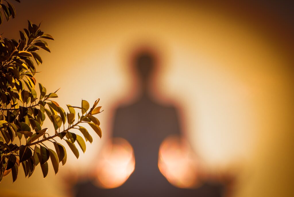 figura in meditazione avvolta da luce calda- medipthazione